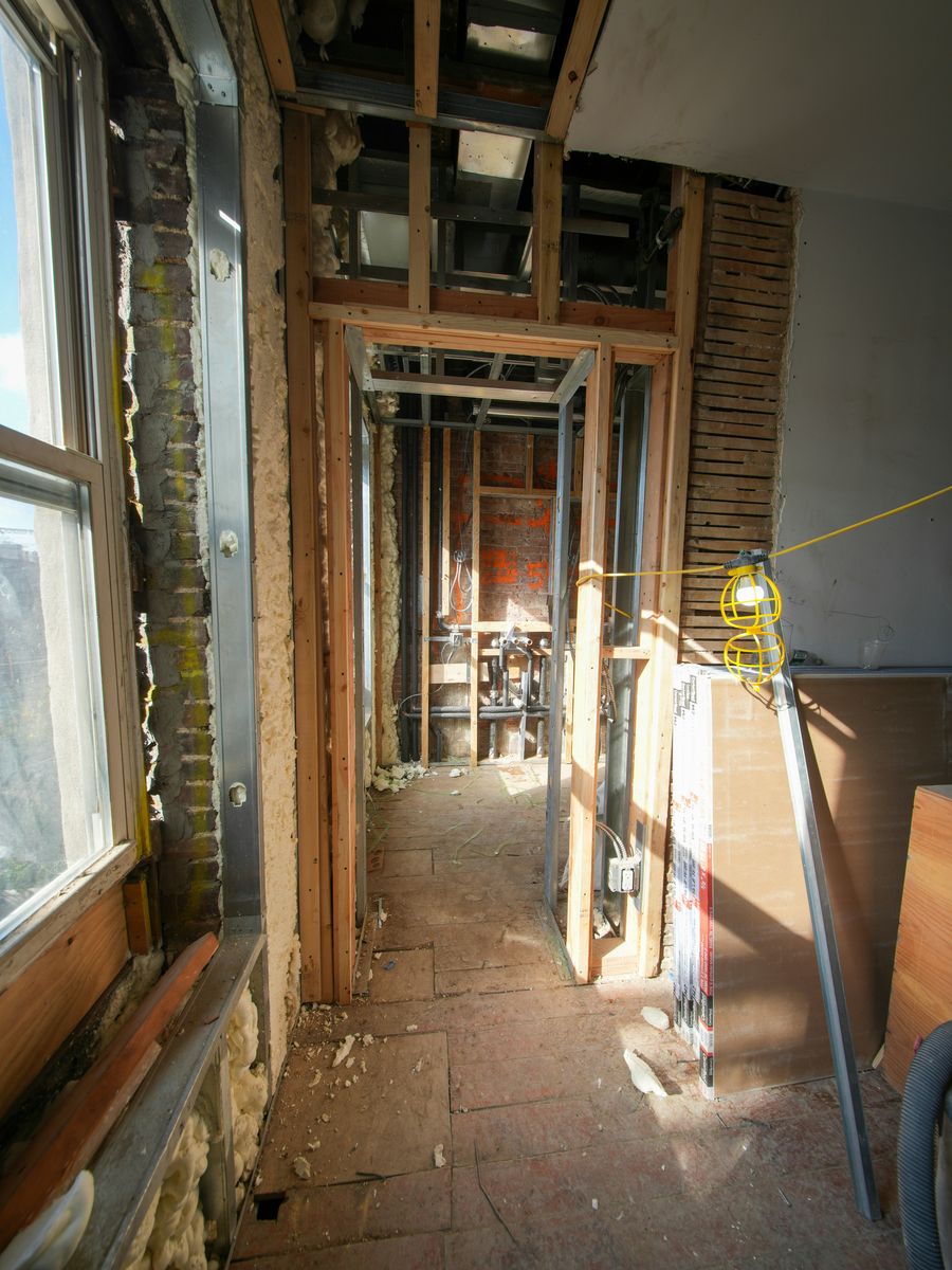 Stock photo of a room under renovation with open framing, debris, and dust